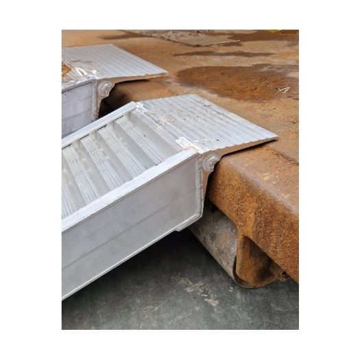 Par kratkih aluminijskih rampi naslonjenih na drvenu podlogu